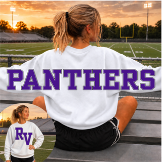 Woman wearing an oversized white Royal Valley Panthers crewneck sweatshirt at a football field, with the PANTHERS wordmark in purple across the back