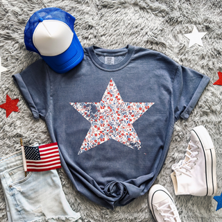 Denim Comfort Colors tee with a large red white and blue floral star graphic styled with denim shorts and sneakers