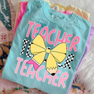 pastel stack of shirts with pencil bow teacher graphic on front
