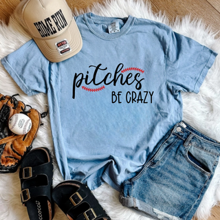 Washed denim Comfort Colors tee flat lay with pitches BE CRAZY baseball stitch script design with hat glove and baseball
