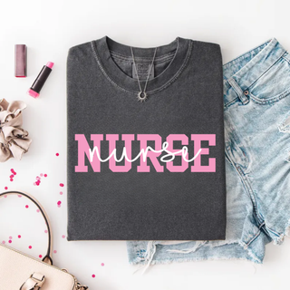 Folded grey Comfort Colors Pop of Pink Nurse Graphic Top with bold pink varsity NURSE lettering and white script overlay