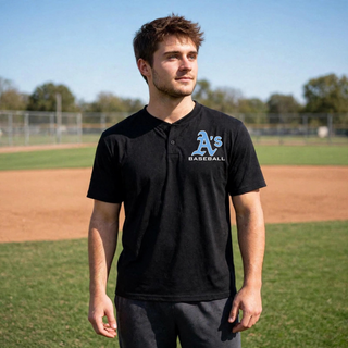 Model wearing black Prime Athletics Baseball A's Logo two-button performance jersey with light blue A's script over BASEBALL text on the left chest