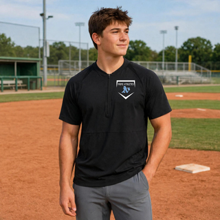 Man wearing a Black Prime Athletics Baseball Home Plate Logo Half-Zip Short Sleeve Jacket with home plate emblem on left chest, on a baseball field