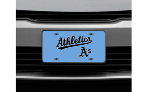 Prime Athletics Baseball license plate featuring the script Athletics wordmark and A's lettering in black on a Carolina blue background, shown mounted on a vehicle front grille