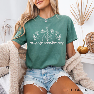 Light green Comfort Colors tee with Raising Wildflowers line art floral graphic in white
