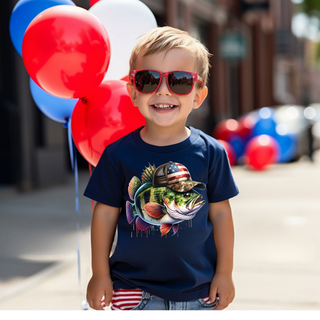 Smiling boy in navy youth tee with patriotic bass fish graphic, red sunglasses, red white and blue balloons
