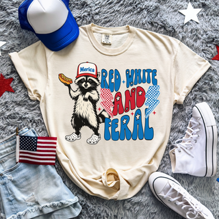 Ivory tee with RED WHITE AND FERAL raccoon holding hotdog in Merica hat patriotic graphic front view flat lay

