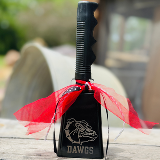 9 inch black game day cowbell with laser engraved bulldog Dawgs logo and red ribbon accents on wood background