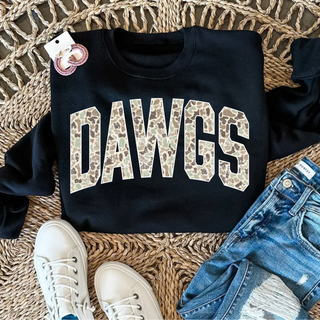 Black crewneck with distressed camo Rossville Dawgs block lettering styled on wicker surface with distressed jeans and white sneakers
