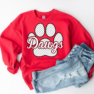 Red crewneck with polka dot paw print and Dawgs script design, flat lay styled with distressed denim on white background
