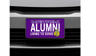 Purple front license plate tag on a car grill featuring white Royal Valley FFA Alumni lettering and the yellow FFA emblem with the motto Living to Serve.