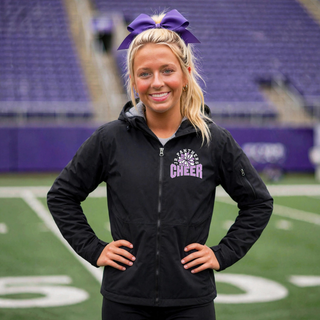 Royal Valley Jr. Panthers Cheer Burst waterproof insulated jacket worn by a cheerleader at a football field