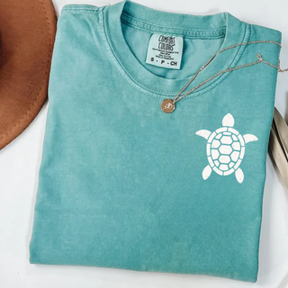 Folded chalky mint Comfort Colors tee with white distressed sea turtle chest graphic
