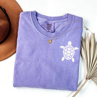 Folded violet Comfort Colors tee with white distressed sea turtle chest graphic
