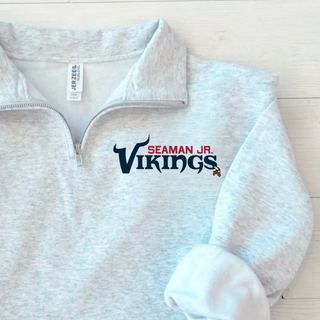 Ash grey Jerzees quarter-zip pullover with seaman jr. vikings signature football wordmark on left chest, flat lay
