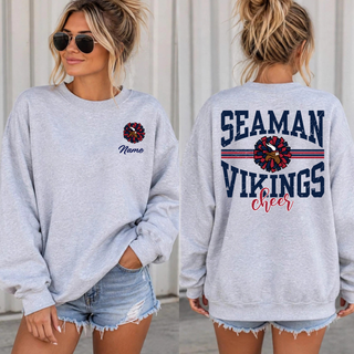 Woman wearing a heather grey crewneck sweatshirt with the Seaman Vikings Cheer personalized name on the front chest and the arched wordmark and pom graphic on the back