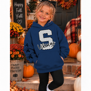 Girl in a navy hoodie with a white polka dot letter S outlined in black and black Vikings script on the front, with three black Viking helmet graphics down the sleeve, standing on a fall porch with pumpkins