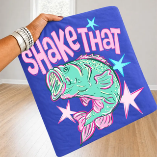 Hand holding flo blue tee with SHAKE THAT bright bass fish pink stars design, youth adult unisex