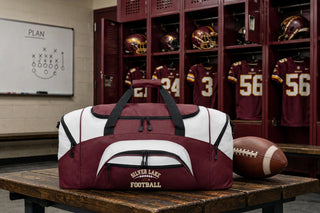 Maroon and white Silver Lake Eagles Football Classic sport duffel bag on bench in locker room with football