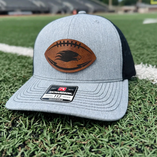 Silver Lake Eagles Football leather patch trucker hat in heather grey and black on football field
