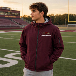 Man wearing Silver Lake Eagles Football Strike Sport-Tek waterproof insulated jacket in maroon with eagle head logo and football wordmark
