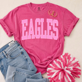 Silver Lake Eagles Pink Out distressed arch top in hot pink Comfort Colors flatlay with jeans, hoop earrings, and pink pom-pom