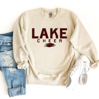 Folded sand crewneck with LAKE CHEER bold block text and Eagles mascot logo front view flat lay
