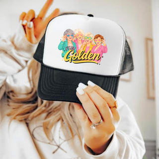Black and white trucker hat with Stay Golden retro ladies graphic
