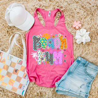 hot pink Next Level racerback tank with beach bum sun mermaid scale patterned letter design, styled with denim shorts and hat
