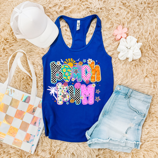 royal blue Next Level racerback tank with beach bum colorful patterned letters, styled with denim shorts and white hat

