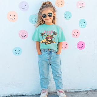 Young girl wearing a chalky mint tee with SUMMER VIBES highland cow in pink sunglasses and palm trees graphic

