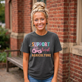 Woman wearing pepper grey Support Local Agriculture t-shirt with pastel rainbow tractor graphic