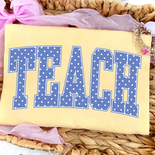 Teach polka dot varsity letters graphic tee on butter yellow shirt with lifestyle styling
