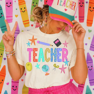 Woman wearing ivory teacher graphic tee with colorful stars pencil and school icons
