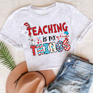 Ash grey tee with Teaching is my Things red patterned letters and book characters, adult unisex