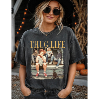 Woman modeling a Thug Life Halloween graphic tee featuring a porch photo design with Thug Life text in gold lettering