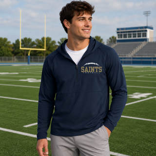 Model wearing a true navy Topeka Saints Classic Football Laces half-zip hooded jacket on a football field