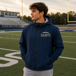 Model wearing a true navy Topeka Saints Classic Football Laces waterproof insulated jacket on a football field