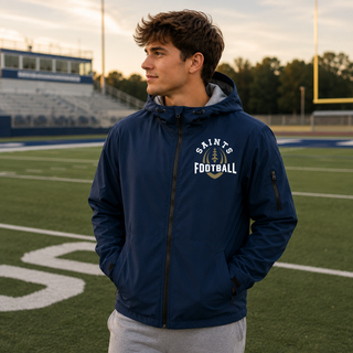 True navy Topeka Saints Football Outline waterproof insulated jacket modeled on a football field