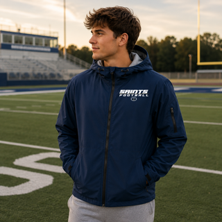 Model wearing a True Navy Topeka Saints Full Speed Football Waterproof Insulated Jacket on a football field