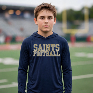 True navy Topeka Saints textured varsity football performance hoodie modeled on a football field