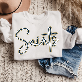 White top with navy and gold script Saints design and cross accent