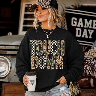 model wearing black crewneck with Touchdown graphic top in camo leopard and checkered pattern lettering