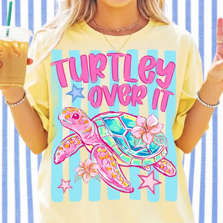 Model holding iced coffee wearing butter tee with TURTLEY OVER IT colorful sea turtle design
