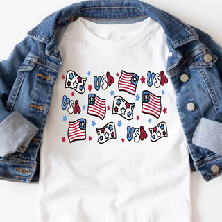 White tee with a red white and blue USA flag and stars repeat pattern graphic laid flat with a denim jacket