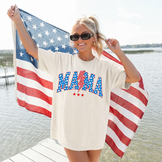 Woman on dock holding american flag wearing ivory tee with vintage all american mama arched star lightning bolt design
