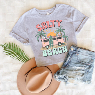 Athletic heather tee laid flat with SALTY BEACH retro groovy lettering pink van surfboard and palm tree graphic
