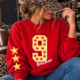 Red crewneck sweatshirt with a gold number 9 filled with maroon stars, Walker in white script lettering, and three gold stars down the sleeve, worn by a model
