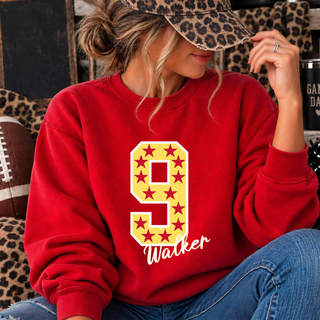 Red crewneck sweatshirt with a gold number 9 filled with maroon stars and Walker in white script lettering underneath, worn by a model