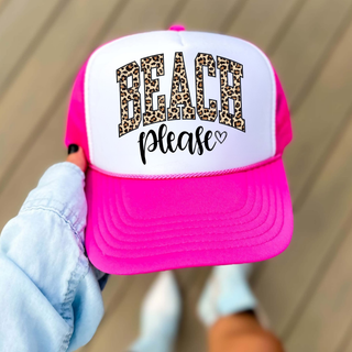Neon pink and white trucker hat with beach please leopard varsity graphic and heart, held up outdoors
